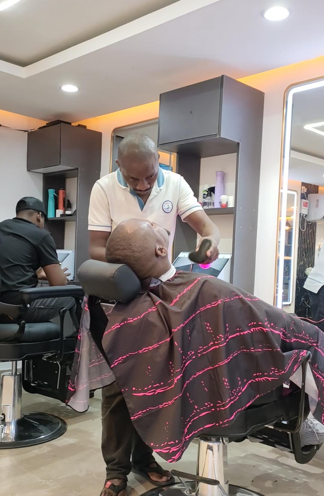 Barber shaving a client at Maimo Mancave